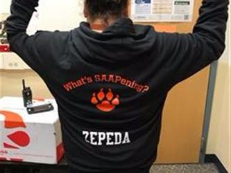 A student pointing to the back of her school hoodie